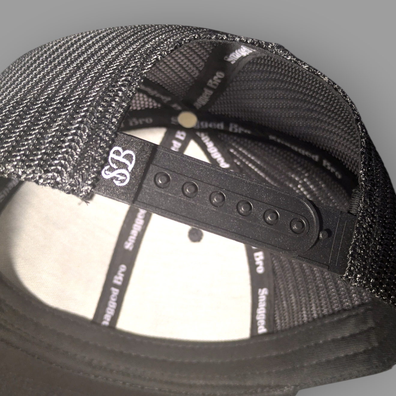Black mesh cap with brand logo on a gray background