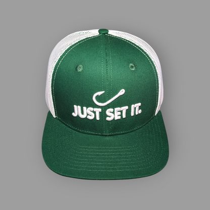 Green cap with white mesh back and 'JUST SET IT.' text on a gray background