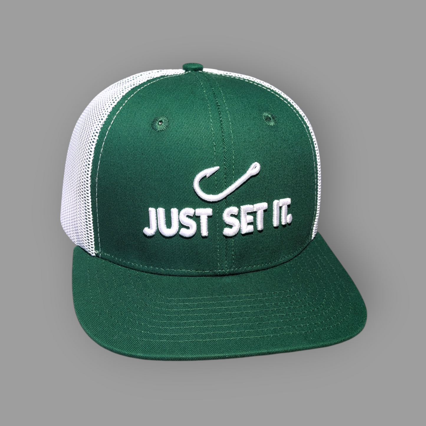 Green and white cap with 'Just Set It' text and fish hook symbol on a gray background