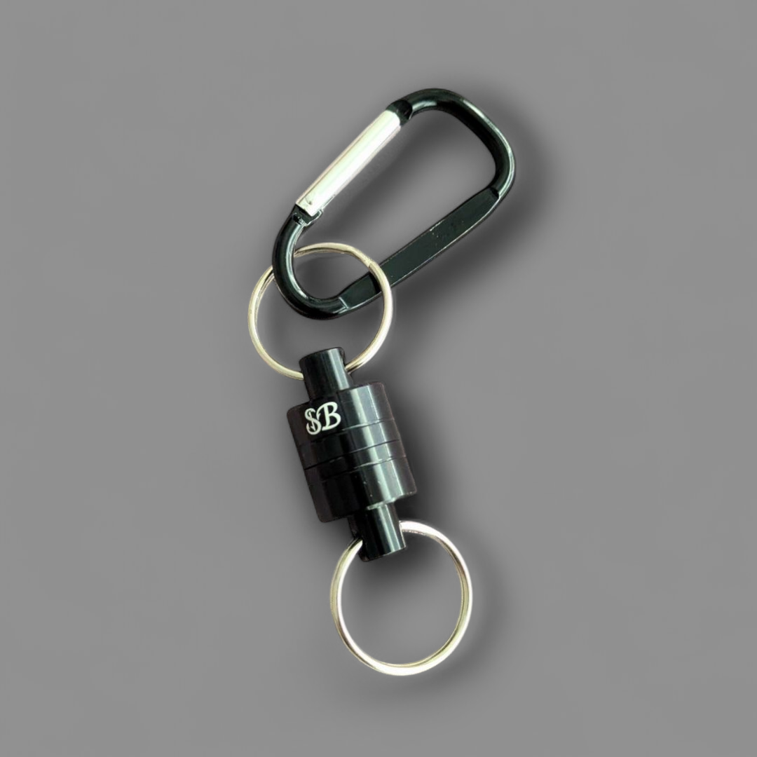 Black carabiner fishing magnet with two keychains on a grey background