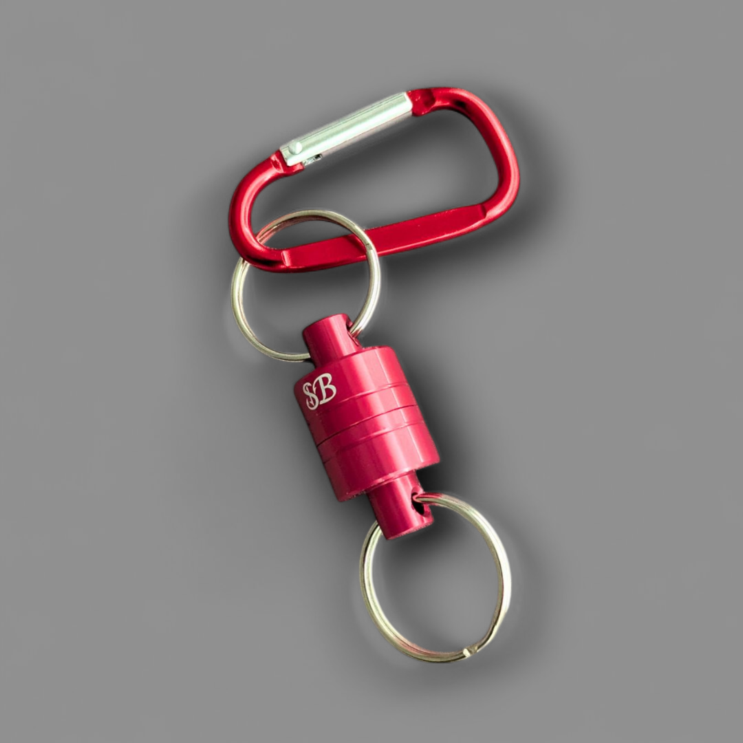 Red keychain fishing magnet with carabiner and lock on a grey background