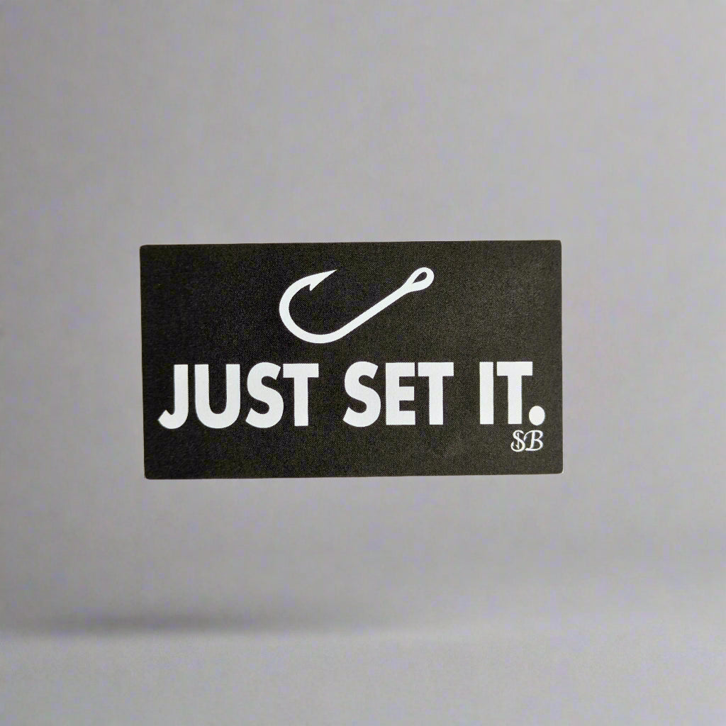 Black and white sticker with 'JUST SET IT.' text on a light gray background