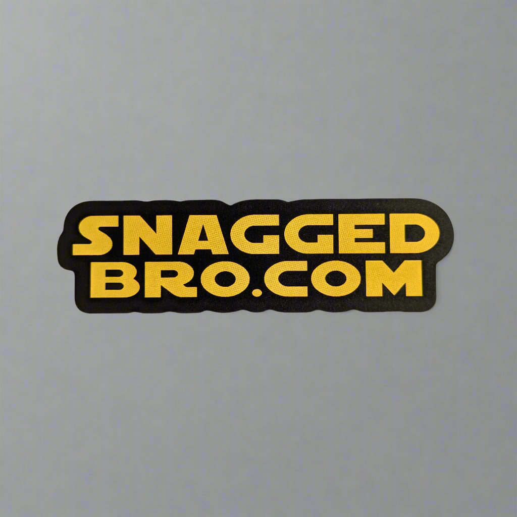 Sticker with 'Snagged Bro.com' text on a light gray background, in star wars style writing.