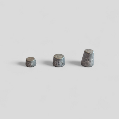 Three small metallic weights on a light gray background
