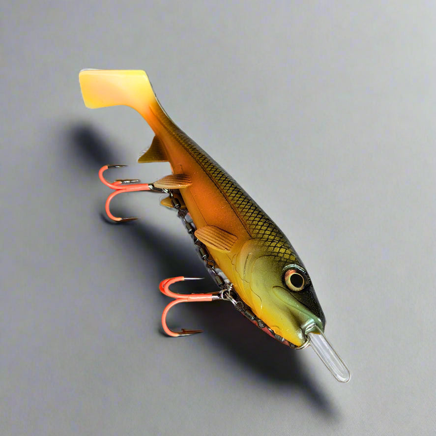 Fishing lure with a yellow and green body with fishing hooks on a grey surface