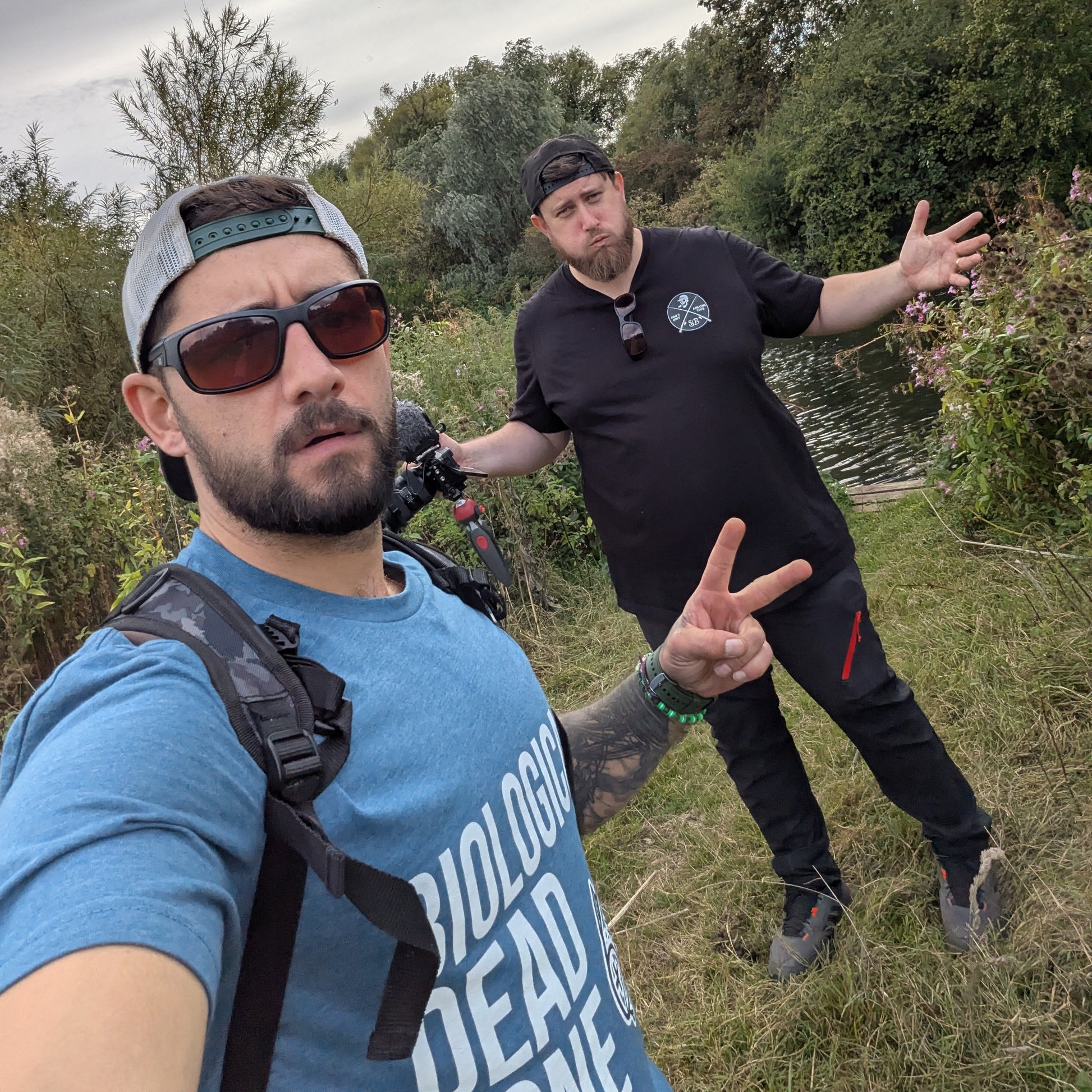 Two men outdoors with trees and sky in the background