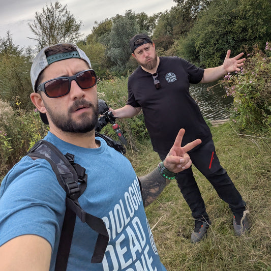 Two men outdoors with trees and sky in the background